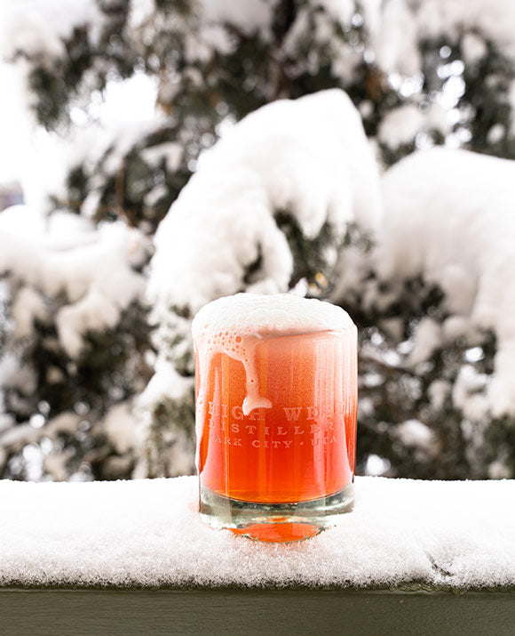A glass of the Capen & Goodrich High West Cocktail outside in the snow.