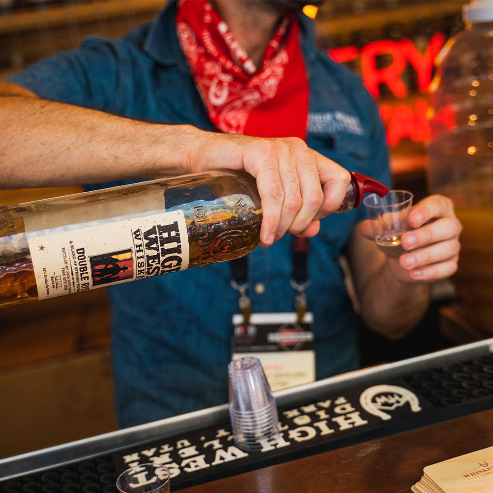 A man pours a taste of High West Whiskey for a taster.